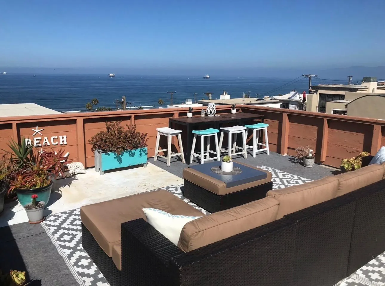Roof deck with "BEACH" sign overlooking the Pacific